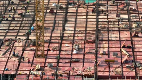 Aerial view of construction workers building a structural framework. Видео 340134434