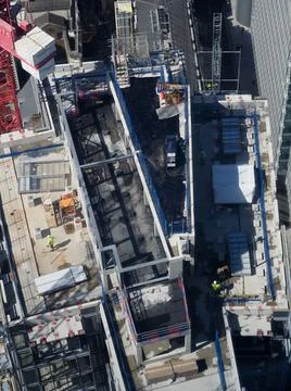 Aerial view of construction workers on top of a tall building seen from above Stock Photos