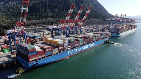 Aerial: View of container ship preparing to depart from container terminal Stock Footage 149780227