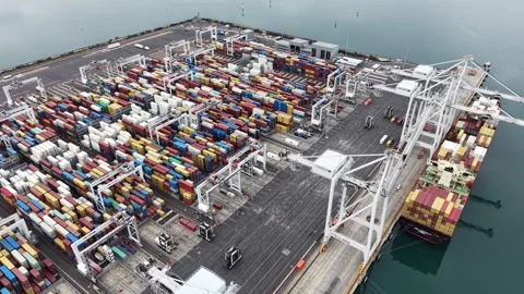Aerial view of container ship unloading at a commercial port terminal Stock Footage 337811393