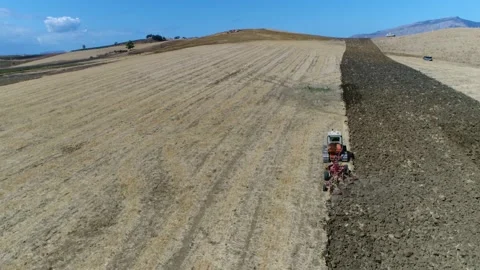 Aerial view of continuous track tractor plowing rough soil 4k Stock Footage 237361607