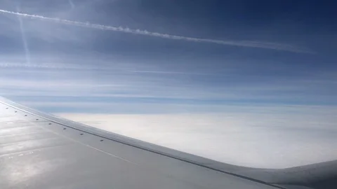 Aerial view contrail, clouds and sky as seen through window of an airplane. 4K Stock-Footage 105097328