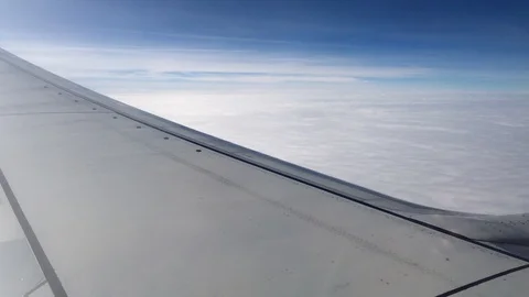 Aerial view contrail, clouds and sky as seen through window of an airplane. 4K Stock-Footage 105097671