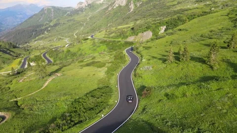 An aerial view of a convertible driving through the Alpine scenery Stock Footage 274913101