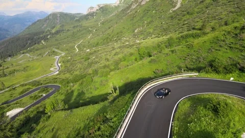 An aerial view of a convertible driving through the Alpine scenery 库存影片 274913198