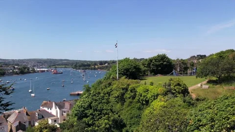 Aerial view of the Cornish flag on a hillside, overlooking boats on a Stock Footage 285581559