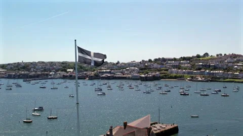 Aerial view of the Cornish flag waving over Falmouth harbor, with boats Stock Footage 285526735