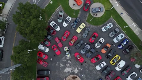 Aerial view of Corvette car meet, dozens of sports cars parked in rows at dusk Stock Footage 346730583