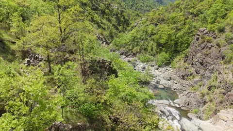 Aerial view of a country stream in spring, flowing between two hills Stockbeeldmateriaal 335236531