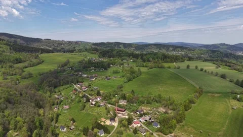 Aerial view of countryside village with patchwork green fields, winding road, Stock Footage 348175653