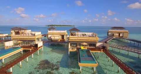 Aerial view of a couple lounging by a swimming pool on an overwater bungalow at Stock Footage
