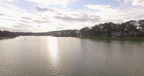 Aerial view a couple at small dock in beautiful Xuan Huong lake at sunrise Stock Footage 130896124