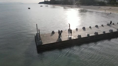Aerial view of couple standing on the jetty to watch the sea view Stock Footage 150110892