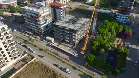 Aerial View: Crane assembly in progress as the operator mounts parts and climbs Vídeo Stock 296025600