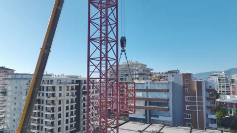 Aerial View: Crane assembly progresses smoothly as the operator climbs ladders Vídeo Stock 296022111