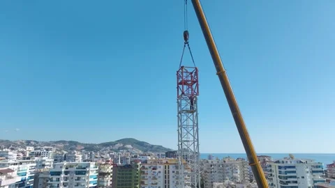 Aerial View: Crane operator scales ladders confidently while assembling parts of Stock Footage 296022092