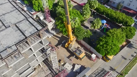 Aerial View: Crane operator works high above, mounting parts and climbing Vídeo Stock 296021012
