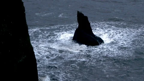 Aerial view crashing waves breaking on strange black rock inside the sea Stock Footage 93614101