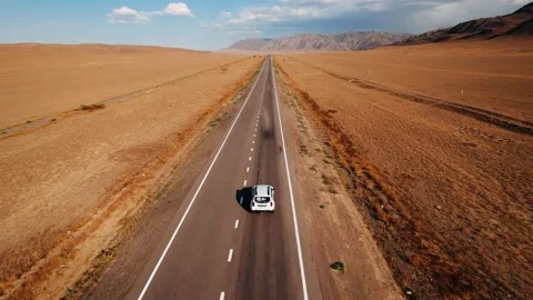 Aerial view of crossover SUV car driving along the empty road near arid desert Vídeos de archivo 237414844