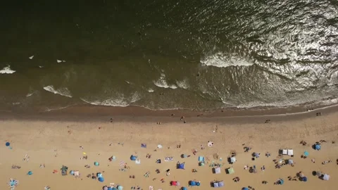 Aerial view of a crowded beach with people enjoying the ocean waves and sand Stock Footage 345442547