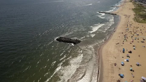 Aerial view of a crowded beach with people enjoying the ocean waves and sand Stock Footage 345442737