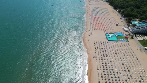 Aerial view of a crowded beach with rows of umbrellas and sunbeds along the Stock Footage 316838785