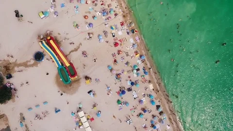 Aerial view of a crowded beach in a sunny hot day. Yellow sand and umbrellas. Video stock 85450025