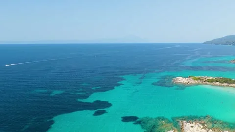 Aerial view of the crystal-clear turquoise waters and rocky coastline of Stock Footage 346704849