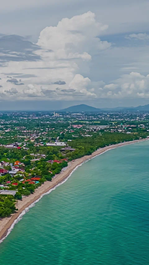 Aerial view of cumulus clouds bursting in sky over a city based on shore of a Stock Footage 311364363
