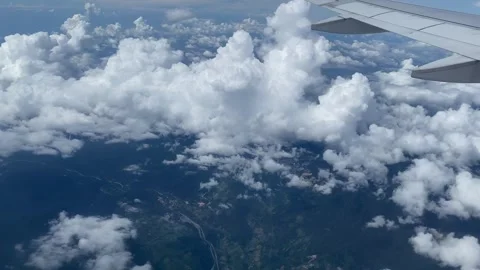 Aerial view of cumulus clouds over a winding river in a vegetated landscape Video stock 339791655