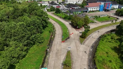 Aerial View of Curving Road Intersection Surrounded by Trees Video stock 347526242