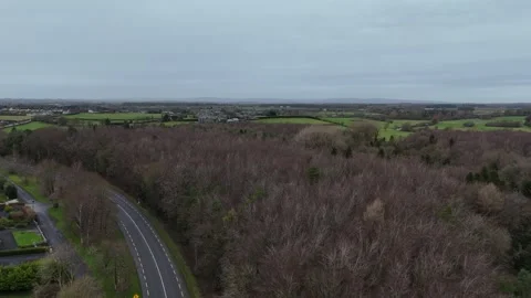 Aerial View of Curving Road by Leafless Trees in Rural Area Stockbeeldmateriaal 332738940
