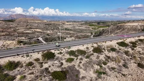 Aerial view of cyclist riding through mountain landscape 스톡 동영상 330052265