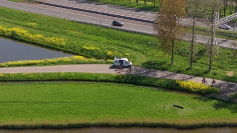Aerial view of cyclists racing through winding roads in rural Netherlands Stock Footage 313362233