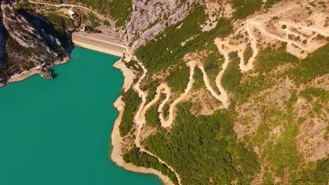 Aerial View of Dam and Winding Mountain Road by Lake Stock Footage 341401014