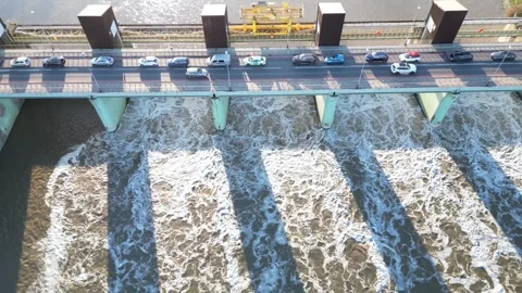Aerial view of dam on river, featuring flowing water and vehicles on bridge Video stock 321402547