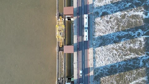 Aerial view of a dam on a river, showcasing flowing water and vehicles Stock Footage 321402538