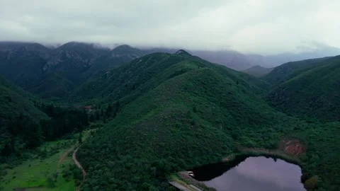 Aerial view of a dam surrounded by mist-covered mountains, Robertson Stock Footage 342334951