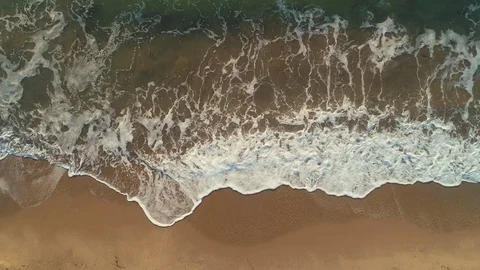 Aerial view of the Dance of Waves Of Blue Ocean washing the Sand and Beach Stock Footage 103332429