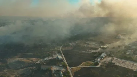 Aerial view of dangerous fire in the forest close to highway and village. Stock Footage 294074179