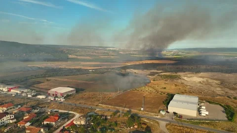 Aerial view of dangerous fire in the forest close to highway and village. Stock Footage 294074490