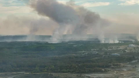 Aerial view of dangerous fire in the forest close to highway and village. Stock Footage 294079180
