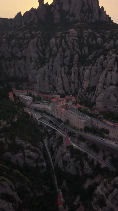 Aerial view from dark peaks over a hazy valley at dusk 스톡 동영상 343325319