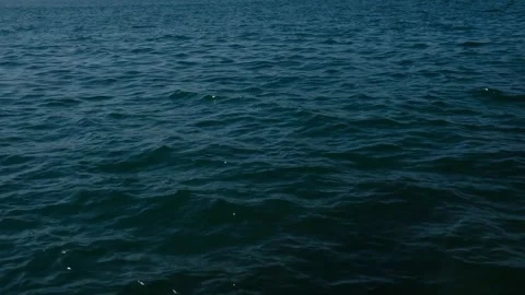 Aerial View of Dark, Slightly Wavy Ocean – Dramatic Sea Texture and Natural Stock Footage 303867596