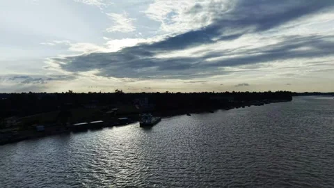 Aerial view of a dark tree-lined shoreline and calm rippling water beneath .. Video stock 344054258