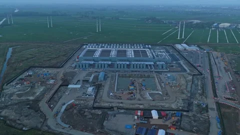 Aerial view of data center construction site surrounded by wind turbines Stock Footage 333638695