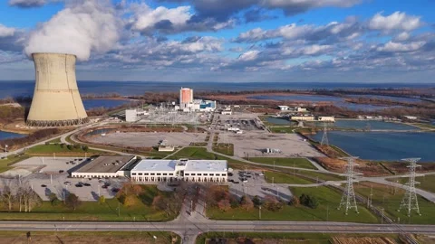 Aerial view of Davis-Besse Nuclear Power Plant cooling tower emitting steam Stock Footage 341322445