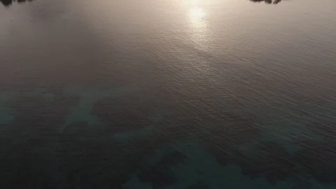 Aerial view at dawn over lighthouse on small island Stock Footage