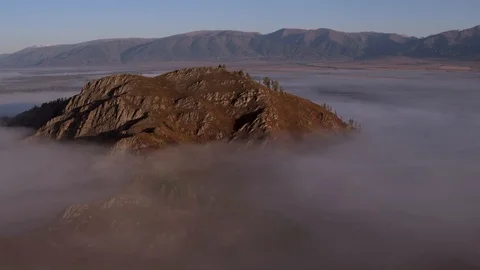 Aerial view At Dawn Over the mountain Above the clouds in the Fog. Stock Footage 123106274