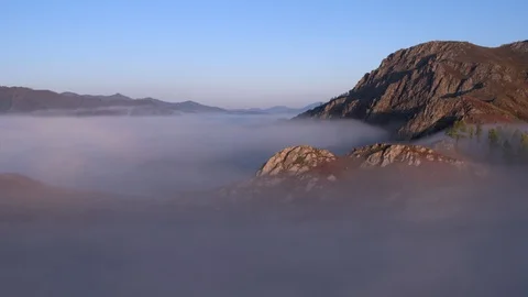 Aerial view At Dawn Over the mountain Above the clouds in the Fog. Stock Footage 123106344